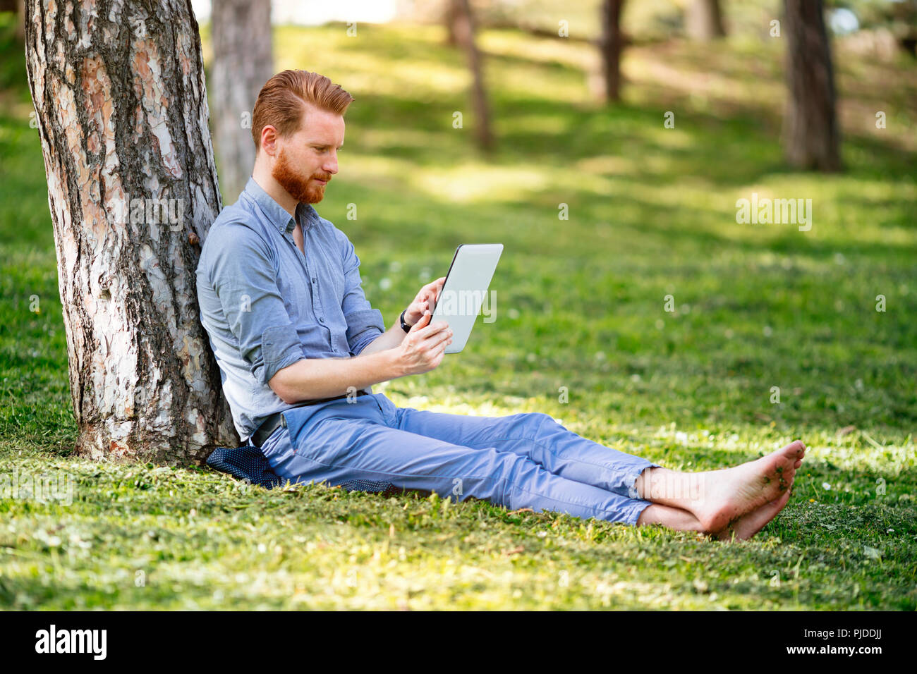 Businessman using tablet in park Stock Photo