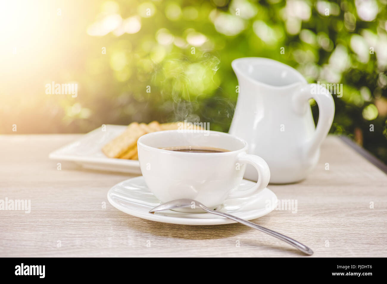 Coffee cup on wooden table morning coffee in the garden - vintage tone Stock Photo