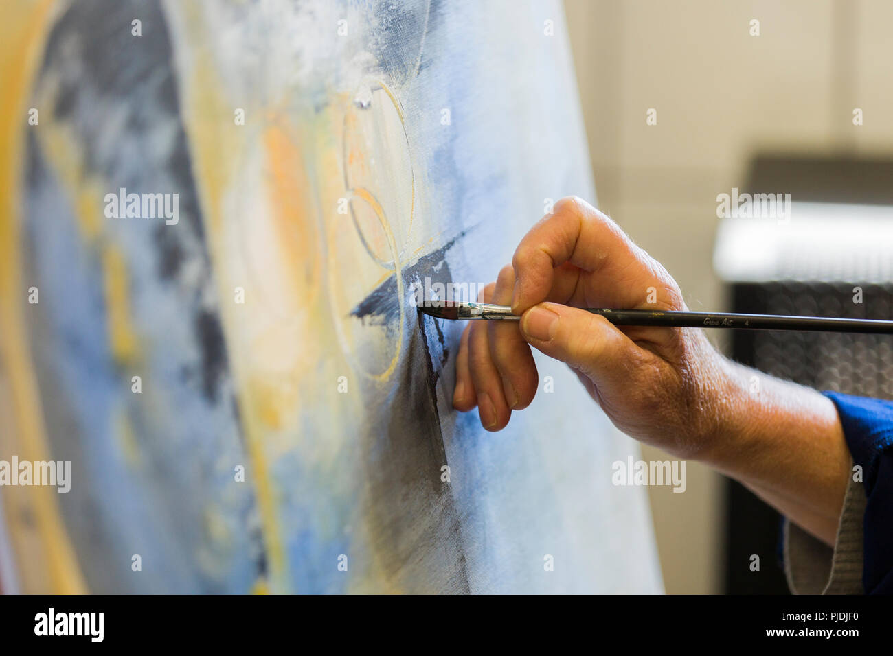 An artist applying paint to their canvas Stock Photo Alamy
