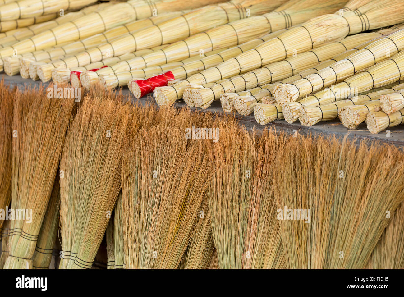 A pile of bamboo brooms in market for sale at Uzbekistan bazaar. Stock Photo