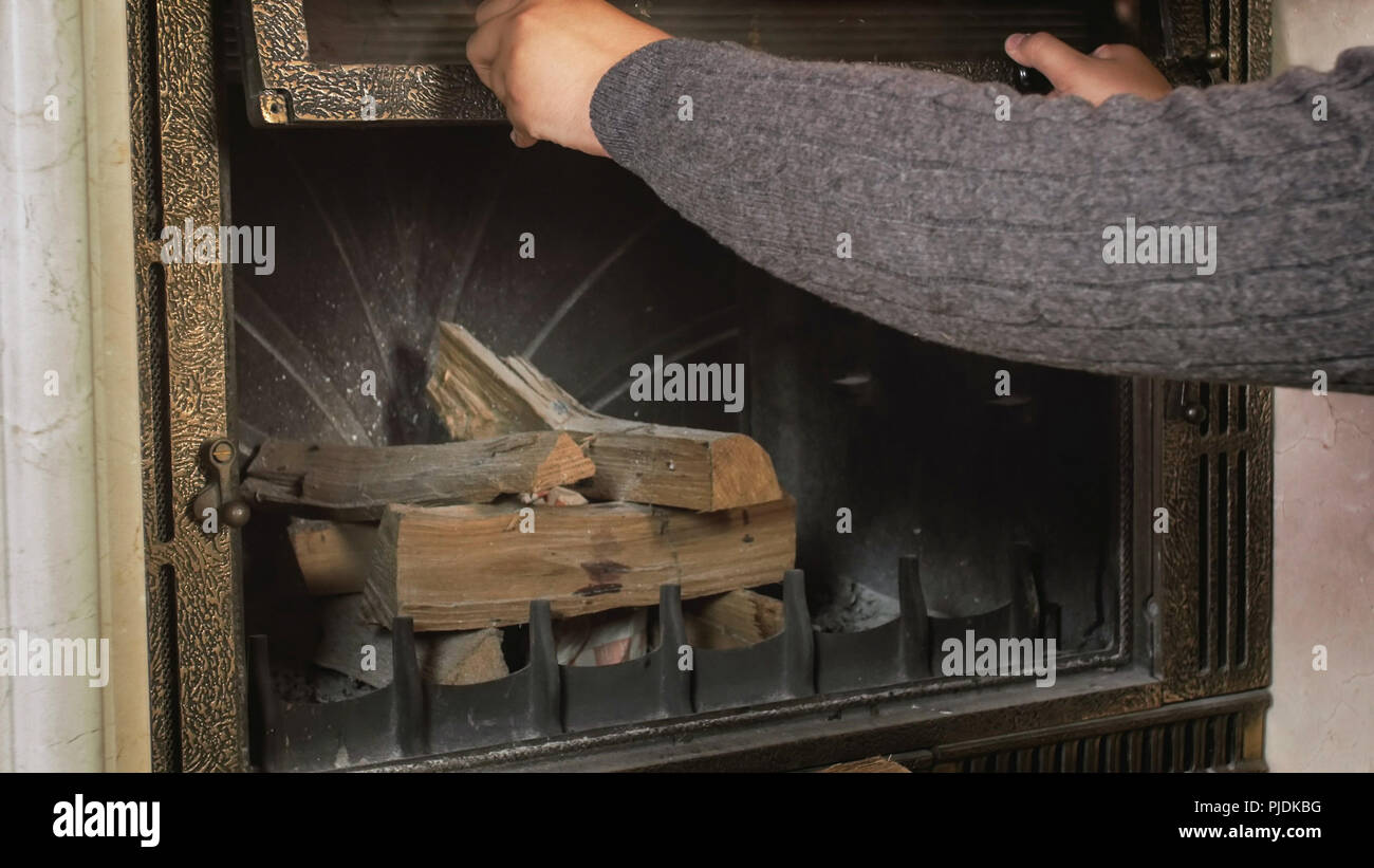 Closeup Image Of Man In Sweater Opening Fireplace Glass Door Stock
