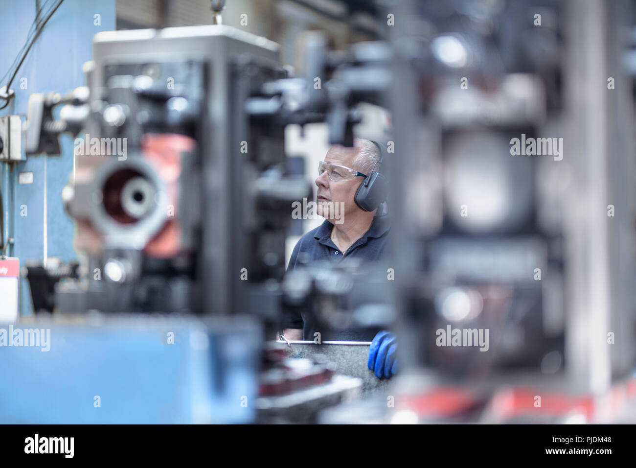 Engineer operating machine in gearbox factory Stock Photo
