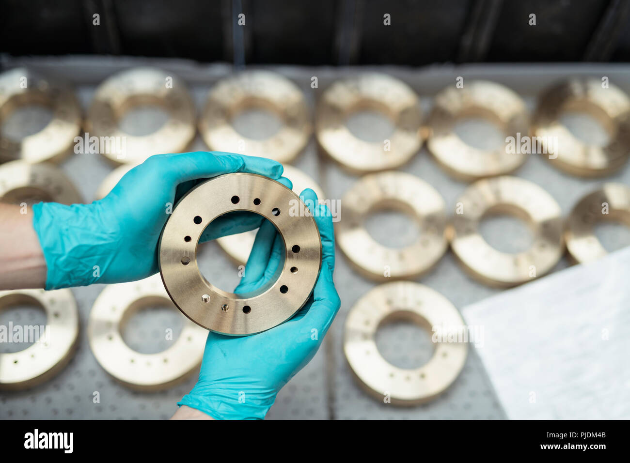 Close up of engineer inspecting bronze parts in gearbox factory Stock Photo