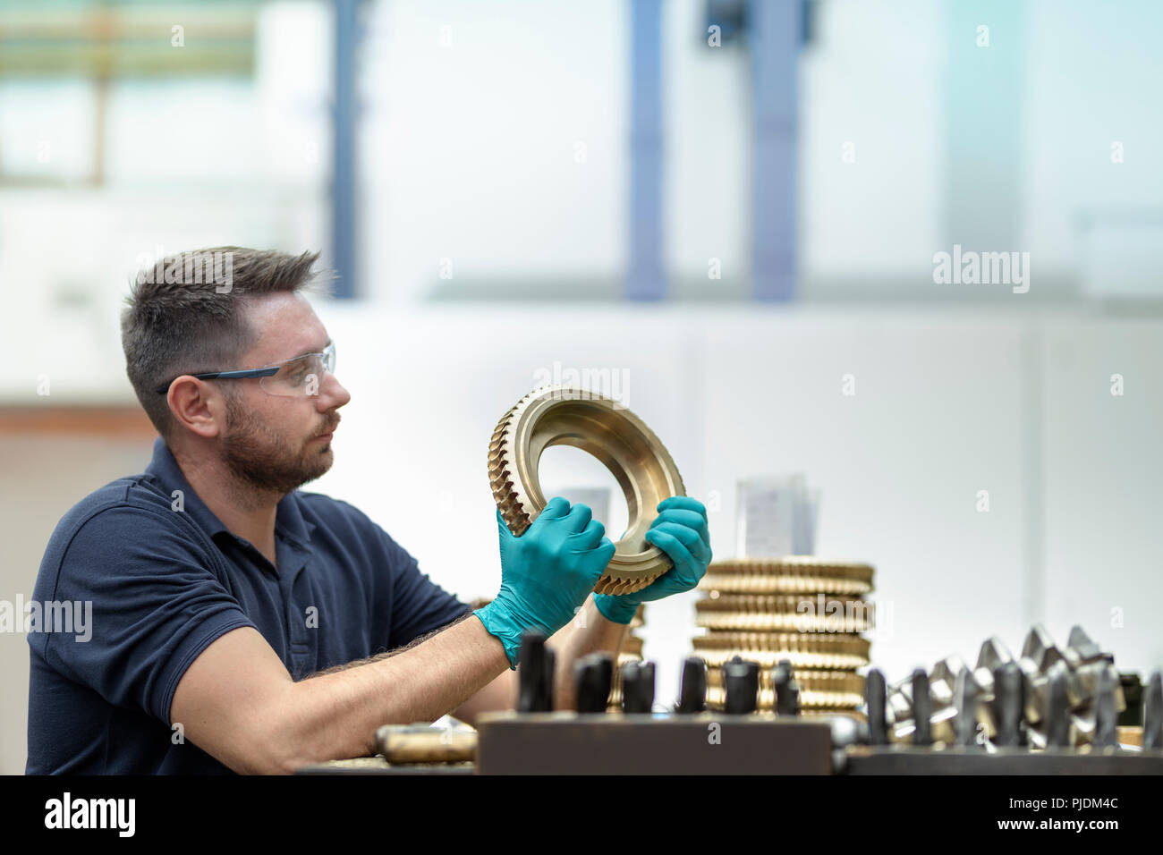 Engineer inspecting bronze parts in gearbox factory Stock Photo