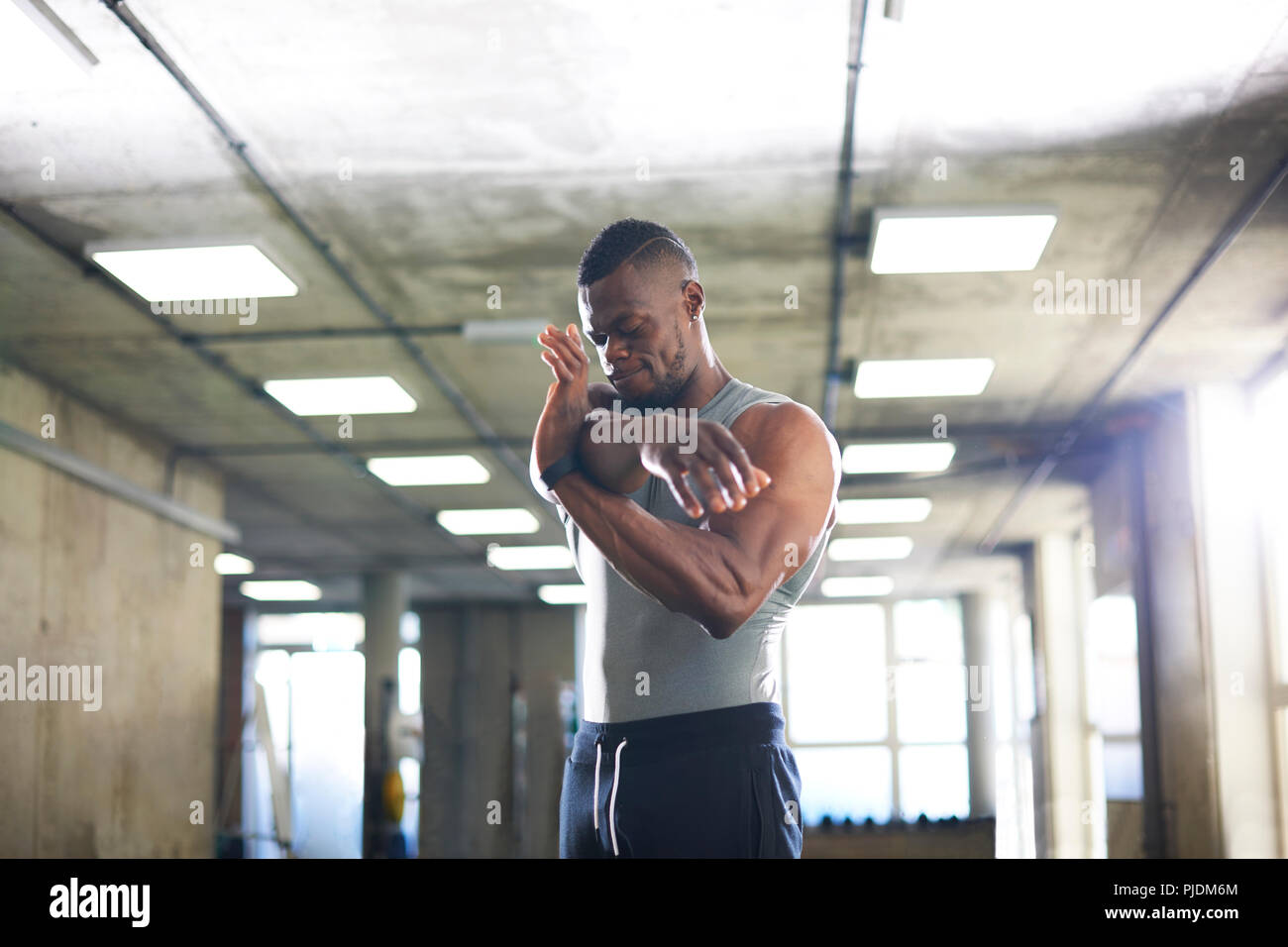 Man doing stretching exercise in gym Stock Photo