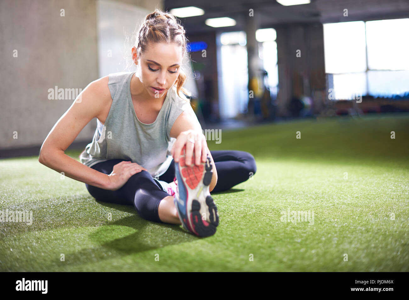 Woman doing stretching exercise in gym Stock Photo
