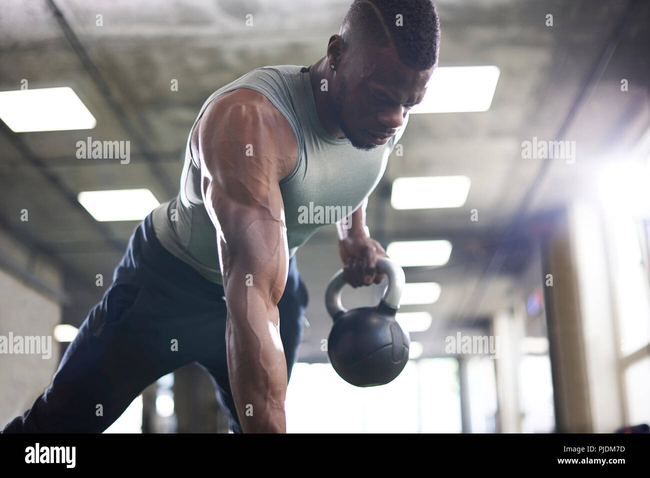 Man doing plank with kettlebells in gym Stock Photo