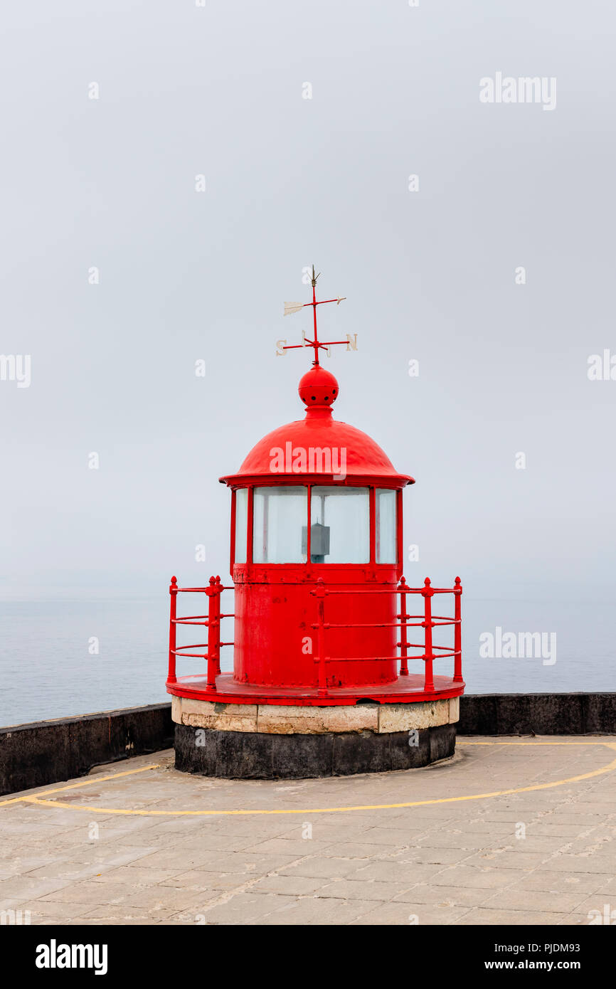 The red lighthouse lamp room on top of the Farol of Nazare in the mist Stock Photo