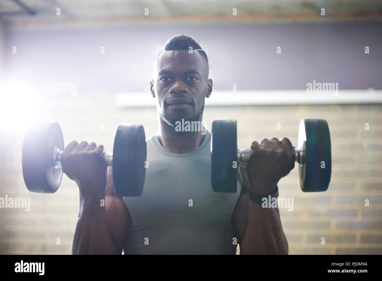 Man lifting dumbbells in gym Stock Photo