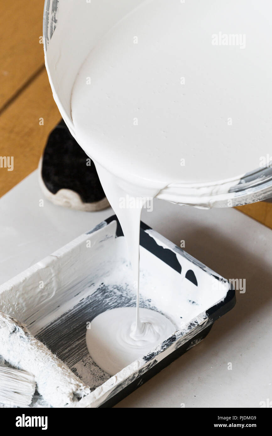 A painter pouring paint into tray Stock Photo Alamy