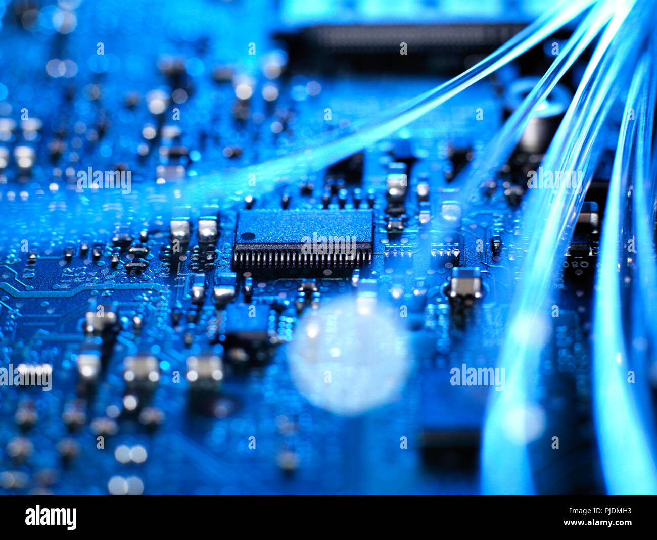 Fibre optics carrying data connecting to the circuit board of a laptop computer Stock Photo