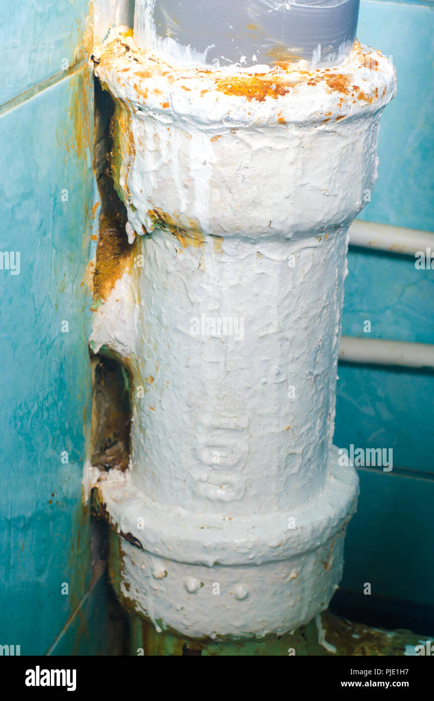 Rusty old toilet waste pipe in need of replacement Stock Photo