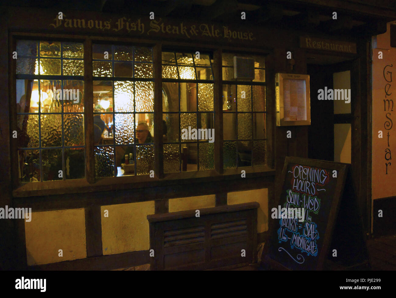 Exeter Devon. Town centre pub on a cold winters evening, a face in the windows is relaxing with
