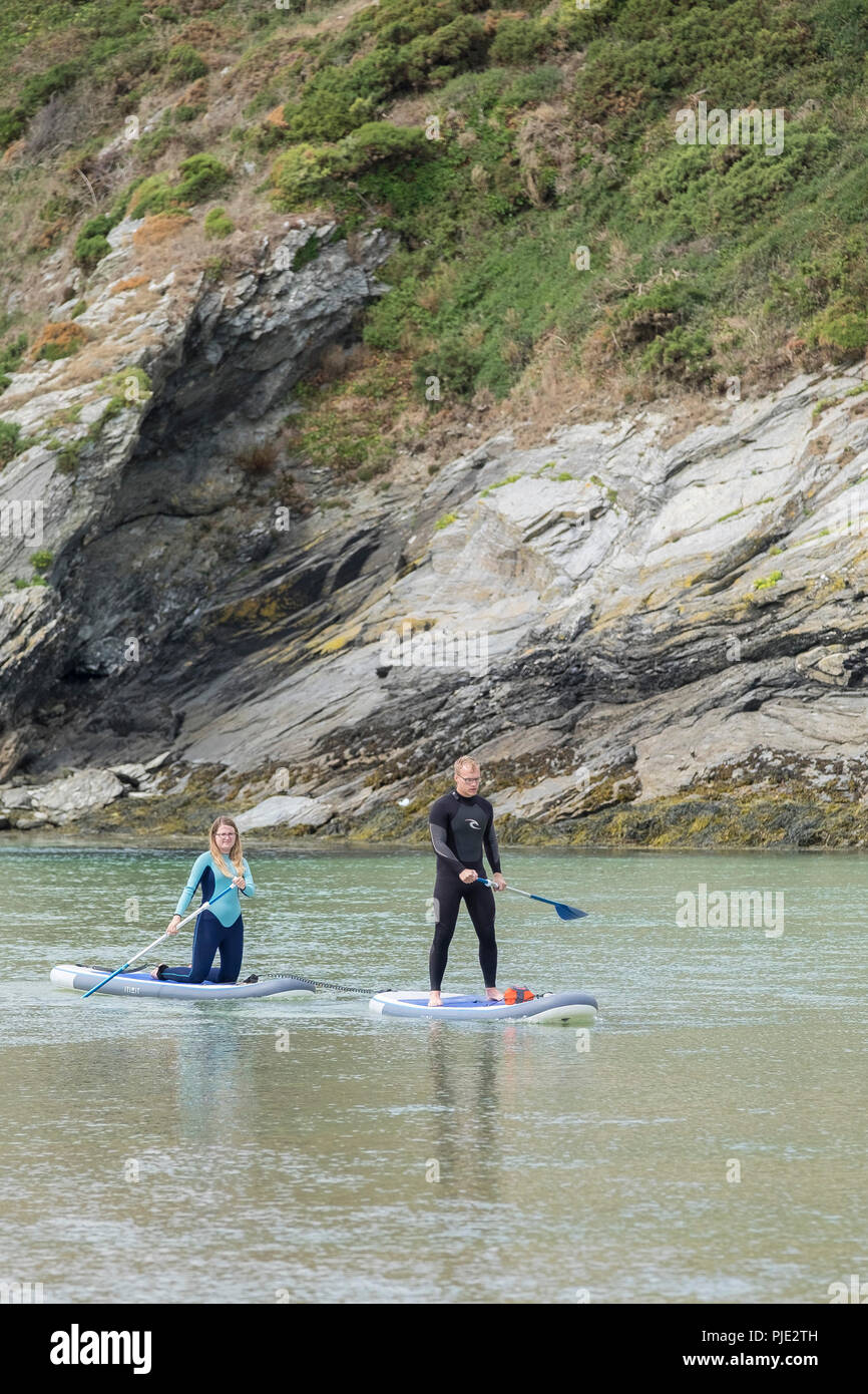 Holidaymakers on stand up paddleboards on the River Gannel at Crantock in Newquay Cornwall. Stock Photo