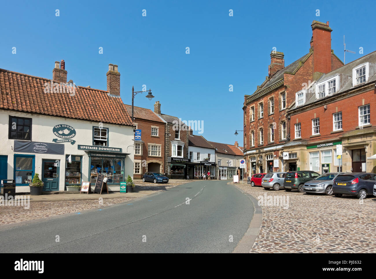 Shops stores in the town centre in summer Market Place Thirsk North Yorkshire England UK United Kingdom GB Great Britain Stock Photo