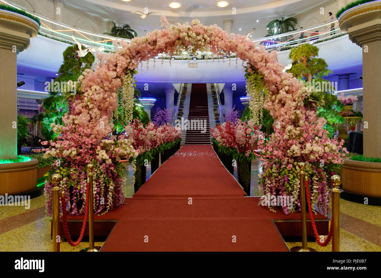 Red carpet and flower arch at a wedding and event hall in Pyongyang, North Korea Stock Photo