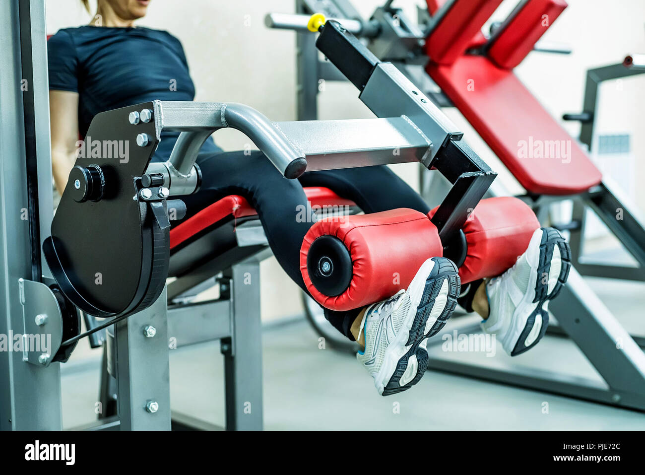 Young woman does leg exercises in gym Stock Photo