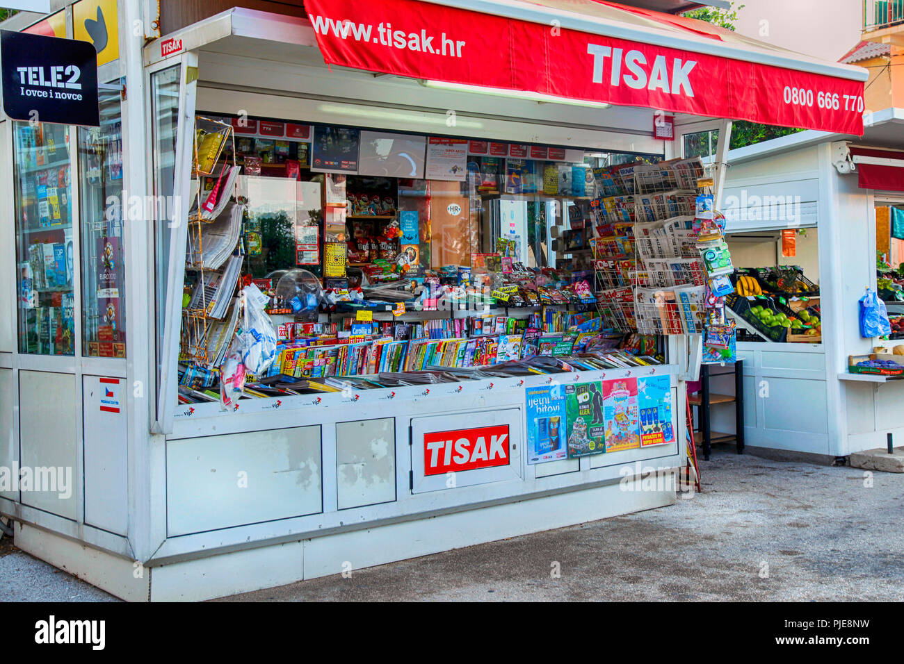 Newspapers, magazines and snack kiosk on the sidewalk near the beach at Baska on the Croatian island of Krk in the Adriatic.Sea Stock Photo