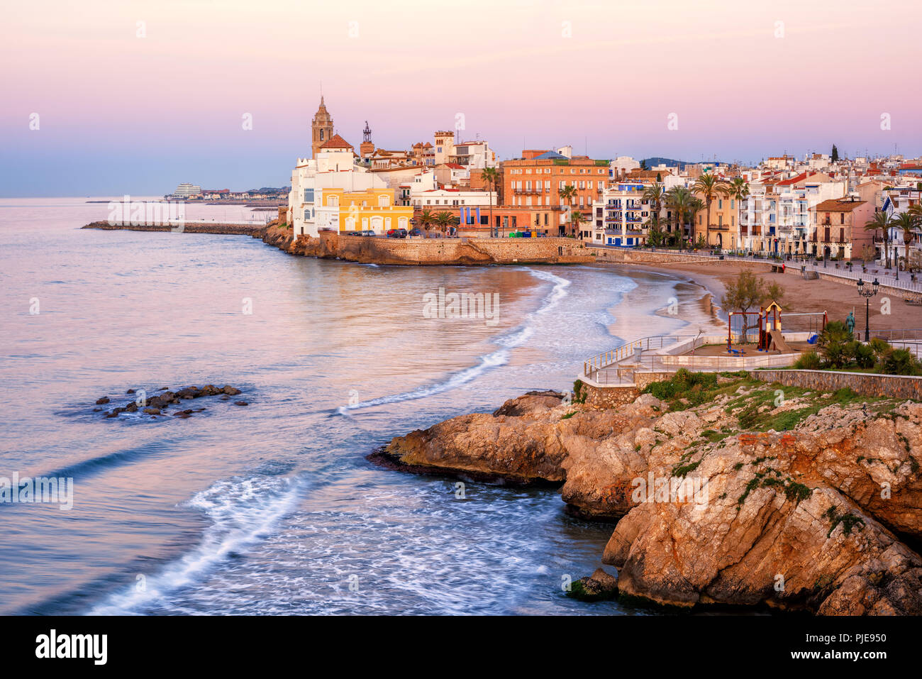 Sand beach and historical Old Town in mediterranean resort Sitges near Barcelona, Costa Dorada, Catalonia, Spain Stock Photo