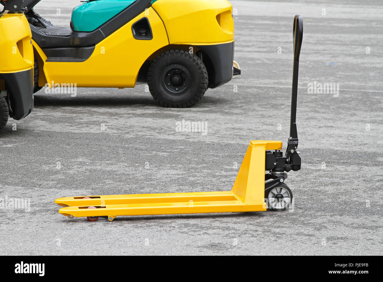 Yellow manual pallet jack truck for transport Stock Photo - Alamy