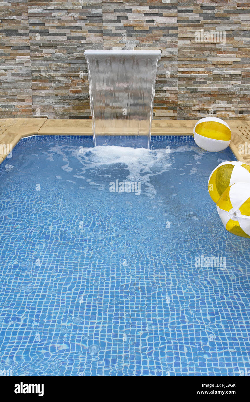 Small modern swimming pool with artificial waterfall Stock Photo