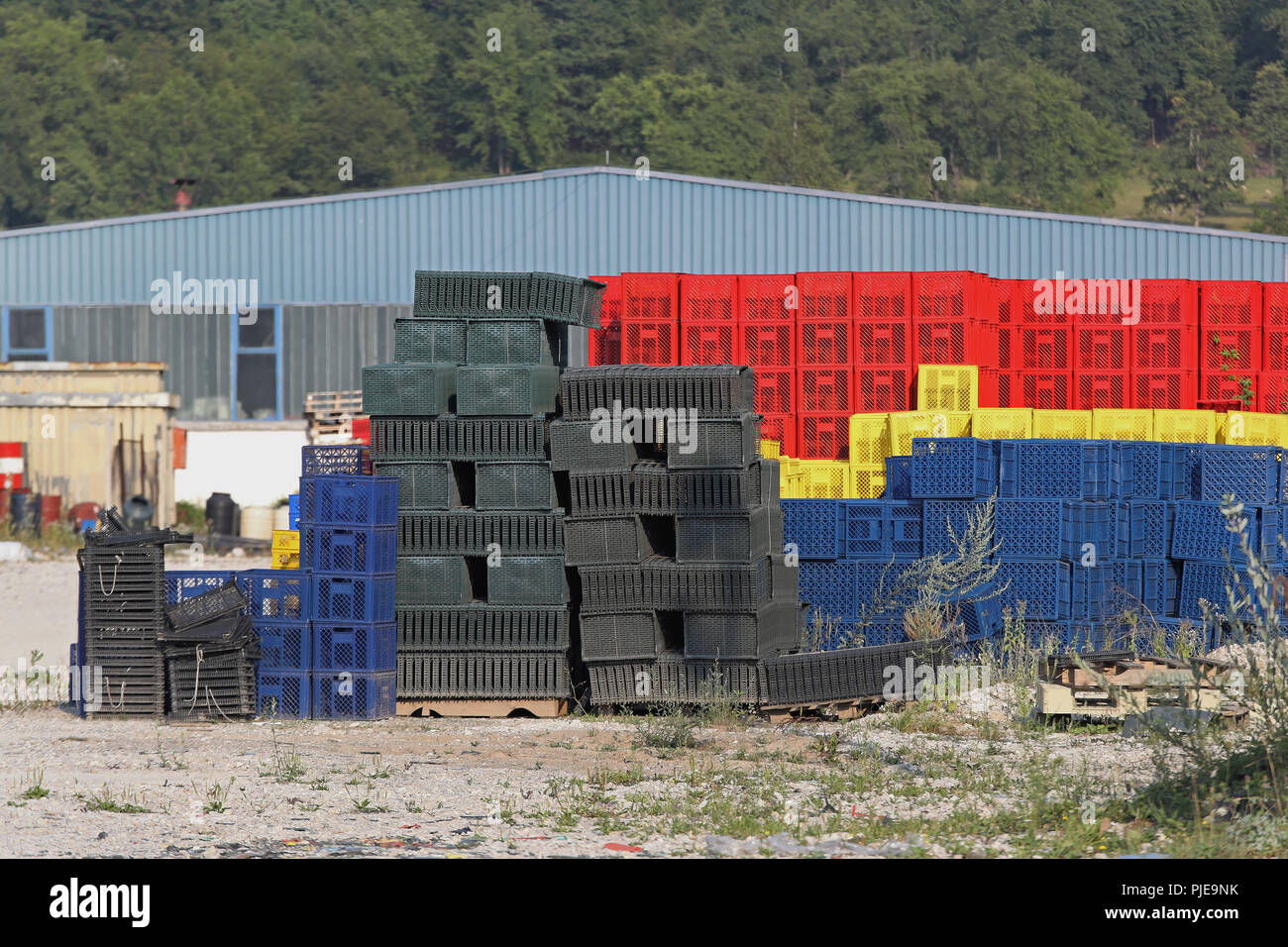 Big piles of plastic crates in front of factory Stock Photo - Alamy