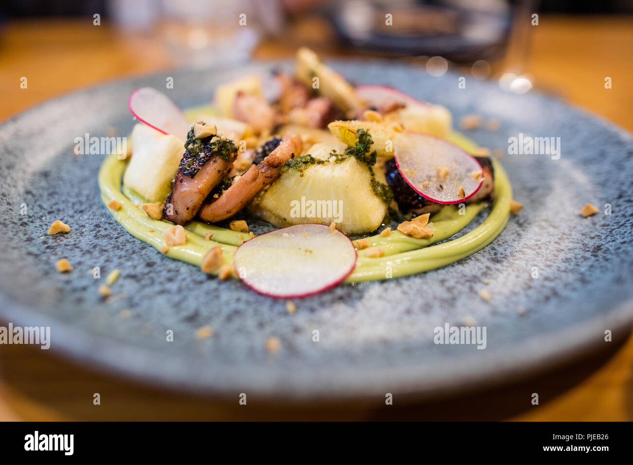 Fresh octopus with cassava, peanuts, and eggplant puree from the tasting menu at the Anker, a fine dining establishment in Puerto Ayora, Galapagos Stock Photo
