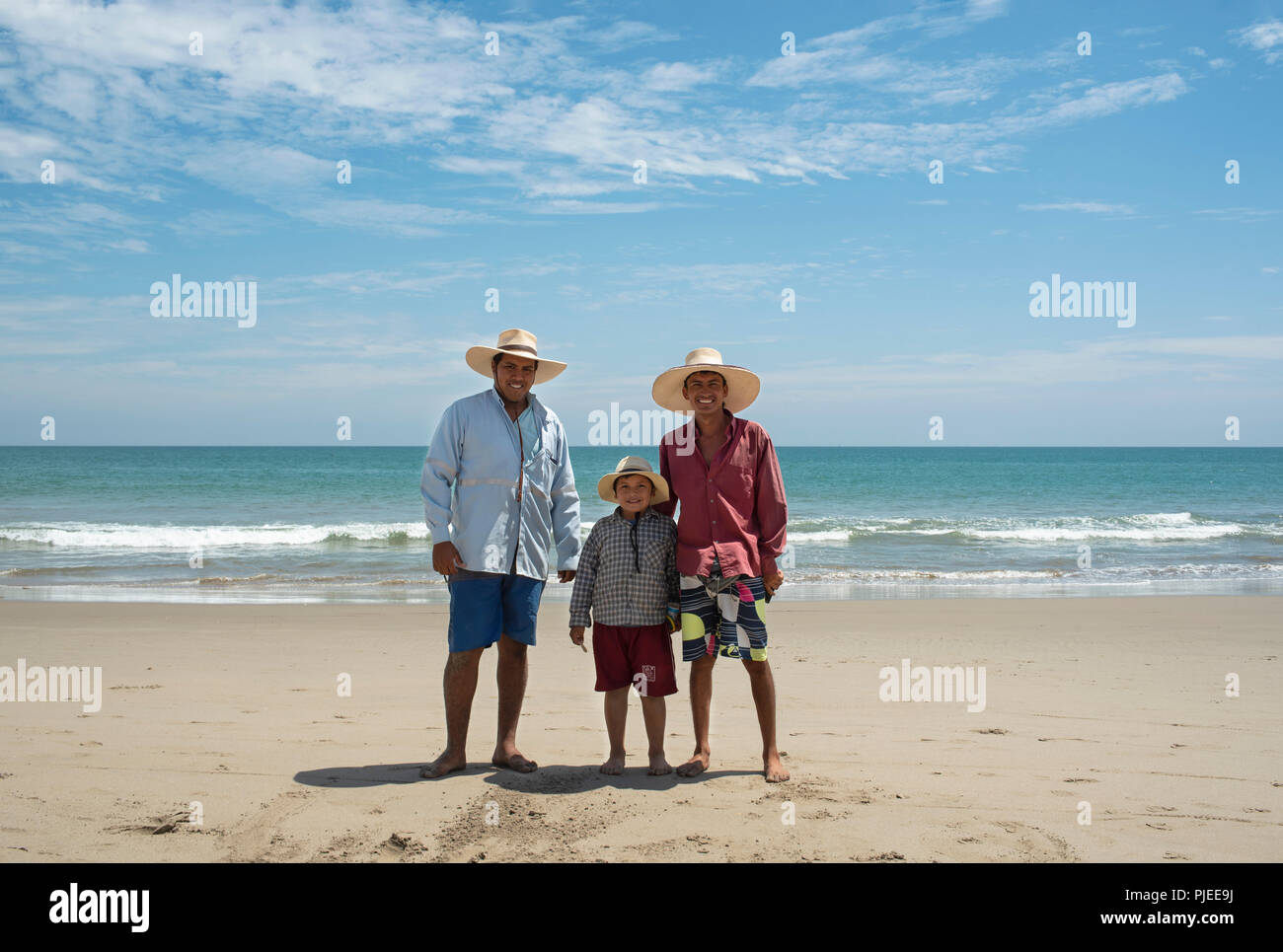 Three Peruvian boys wearing shorts, shirts and straw hats. Environmental portrait on Vichayito beach near Mancora, Peru. Editorial use only. Aug 2018 Stock Photo