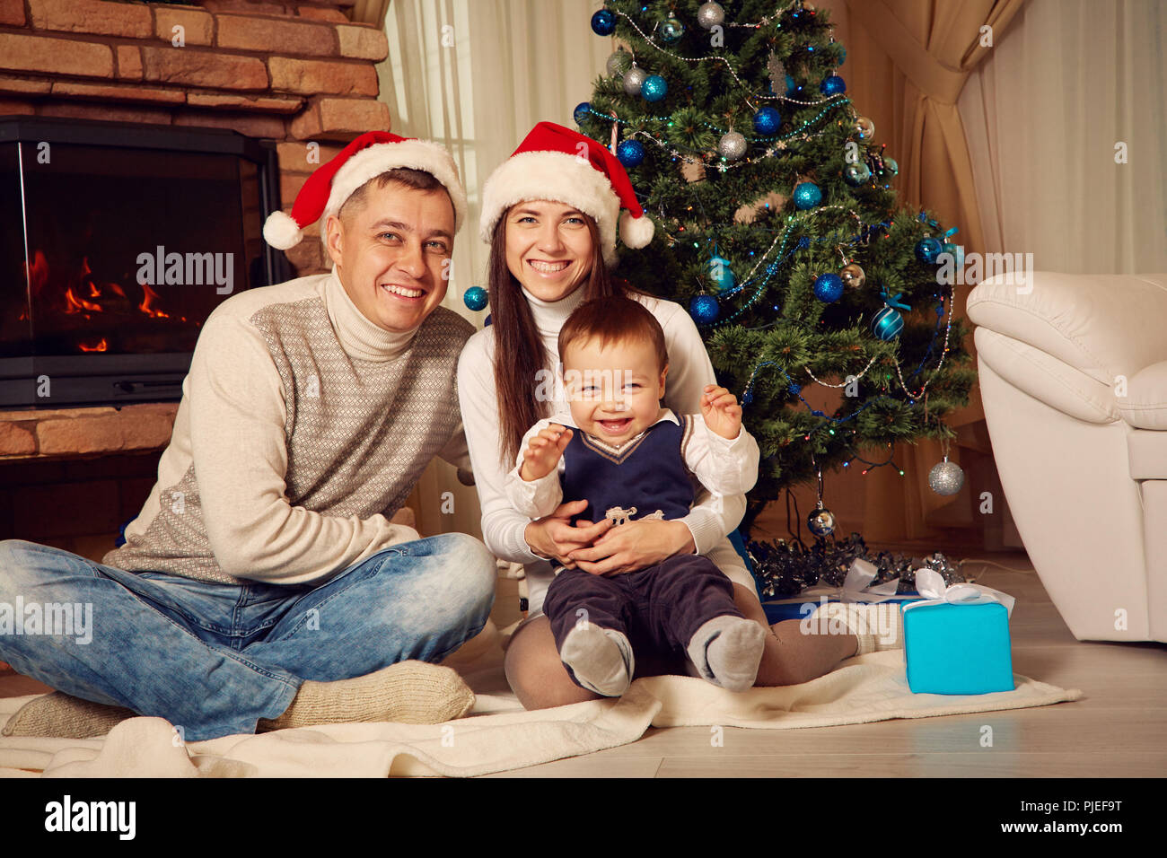family celebrating Christmas on background of the Christmas tree Stock Photo