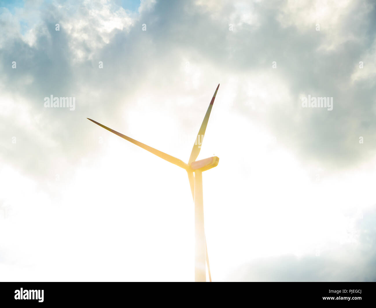 Wind Turbine with Cloudy Sky and Sun Stock Photo
