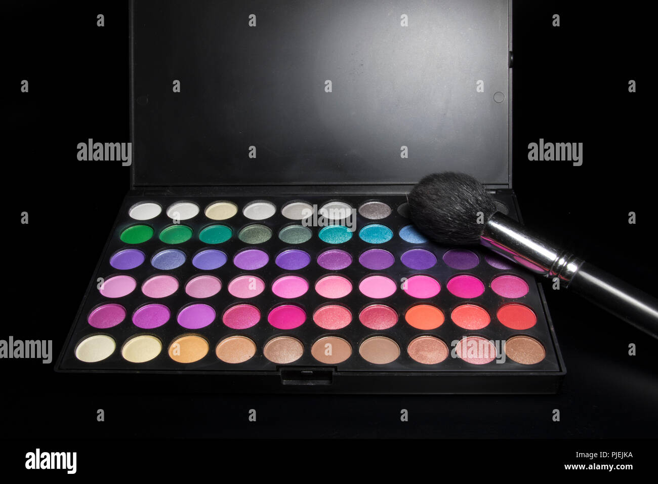 Eye shadows and make up brush on black background. Make up kit from a female beauty industry professional. Stock Photo