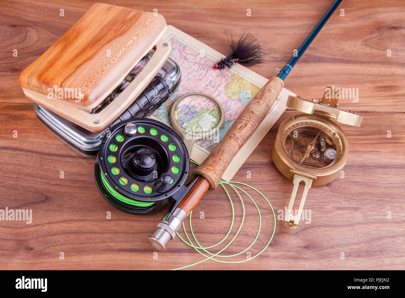https://c8.alamy.com/comp/PJEJN2/fly-fishing-rod-with-a-coil-and-flies-lie-on-old-wooden-boards-PJEJN2.jpg