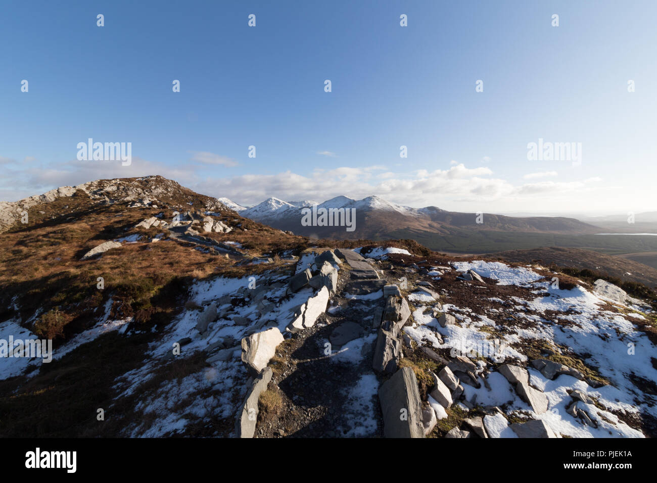 Summit of Diamond Hill in Connemara National Park in winter overlooking the snowcapped mountains of The Twelve Bens. Stock Photo