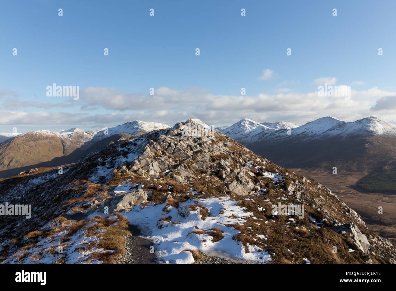 Summit of Diamond Hill in Connemara National Park in winter overlooking the snowcapped mountains of The Twelve Bens. Stock Photo
