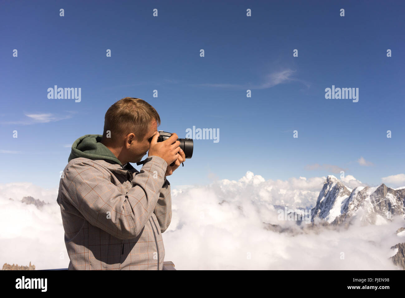 Photographer in Alps with camera at eye mountain background Stock Photo