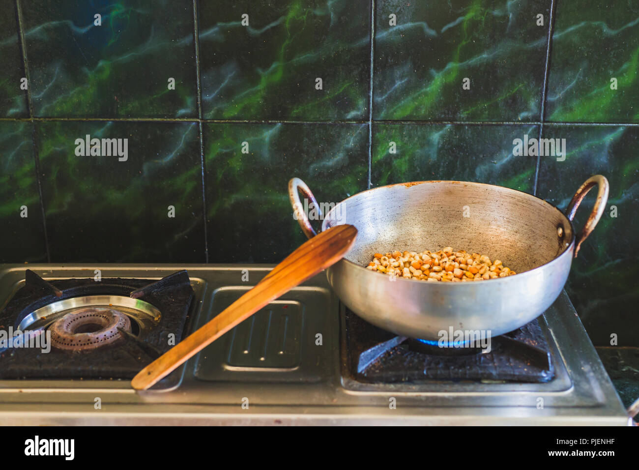 Corn frying on the gas stove in the asian kitchen.Fried corn is a