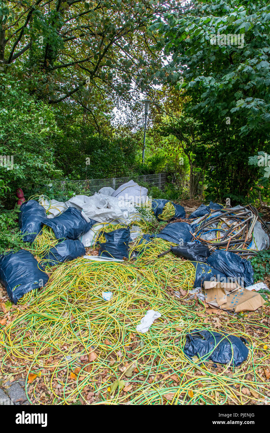 Wild garbage dump on a public parking lot, illegal disposal of