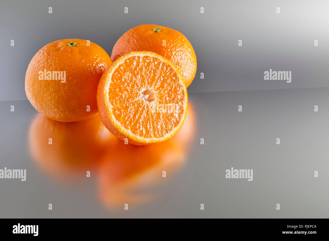 An image of three clementines on grey Stock Photo