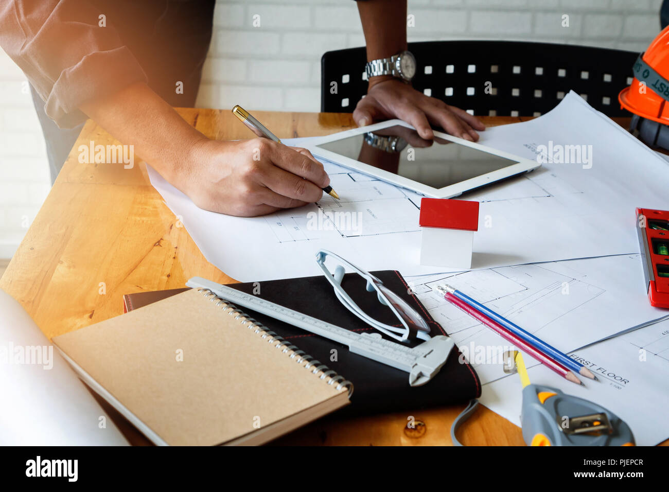 Architect or engineer using pen working on blueprint, architectural concept Stock Photo