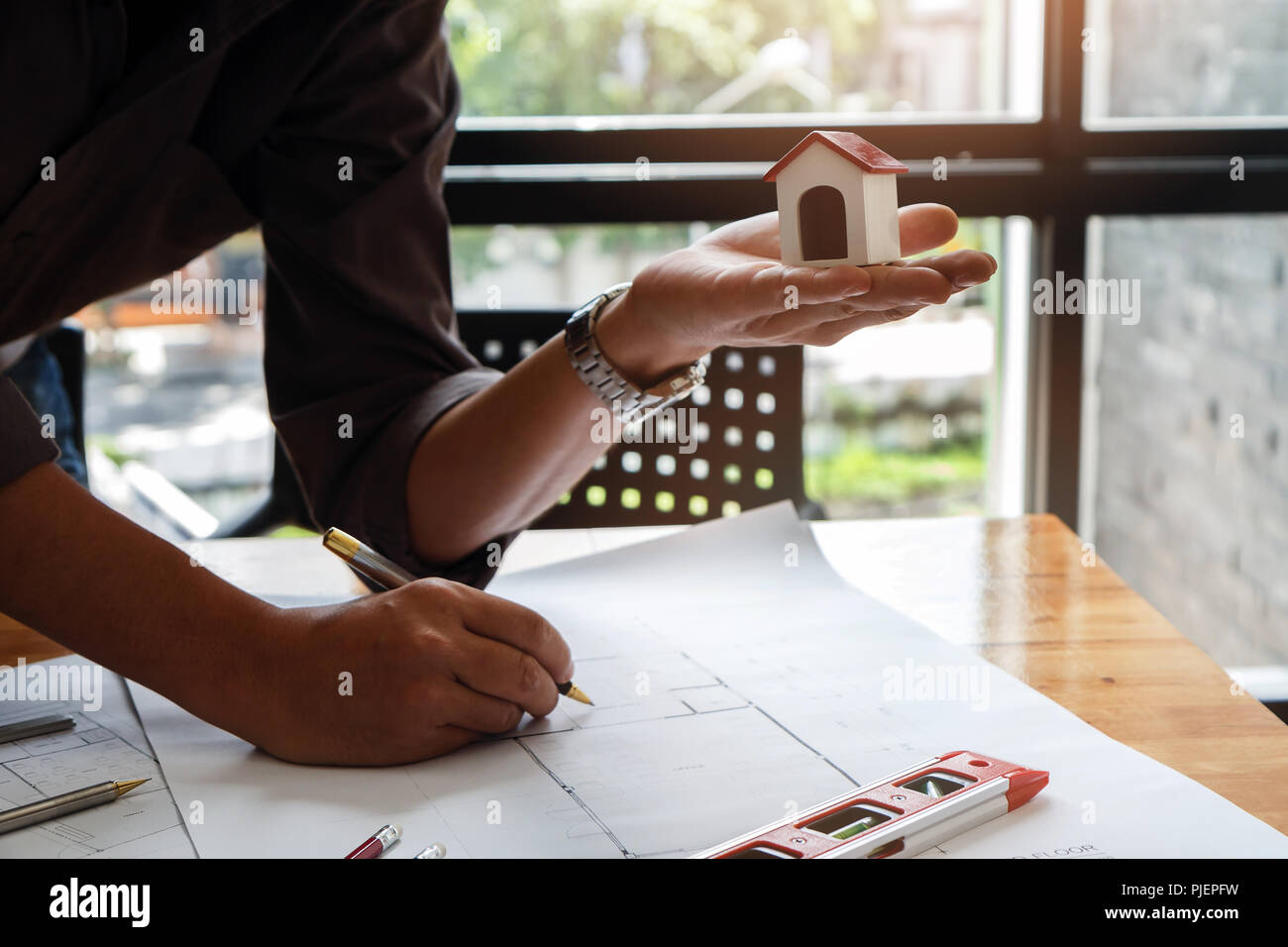Architect or engineer using pen working on blueprint, architectural concept Stock Photo
