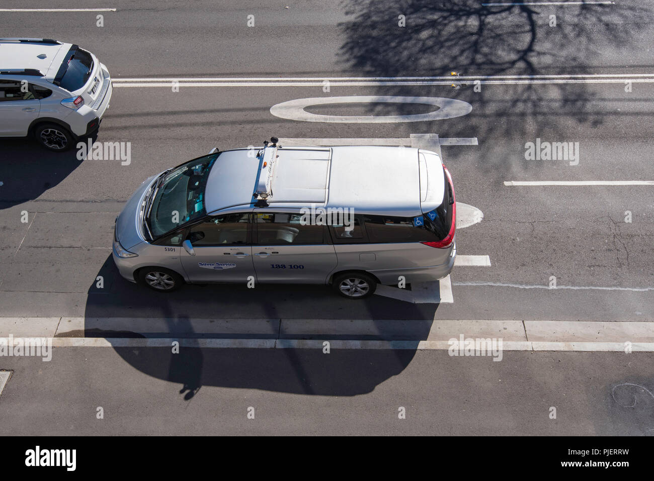 A Sydney Maxi Cab or larger taxi taken from above, driving in a 40km per hour zone Stock Photo