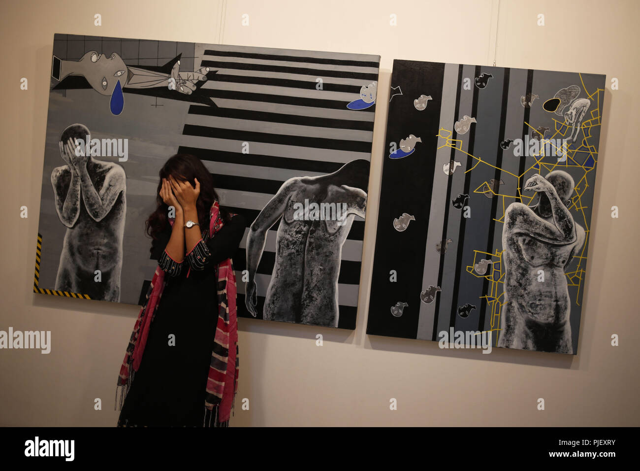 Dhaka, Bangladesh. 5th Sep, 2018. A girl poses for a photo behind a painting at 18th Asian Art Biennale at Shilpakala Academy, a monthly long expiation open national gallery as first Asian Art biennale was held in Bangladesh in 1981. Credit: MD Mehedi Hasan/ZUMA Wire/Alamy Live News Stock Photo