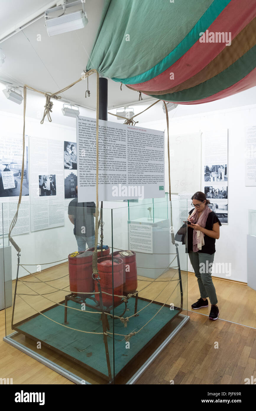 06.09.2018, Berlin: A woman observes an escape balloon in the Wall Museum  at Checkpoint Charlie in Friedrichstraße. On the night of September 16,  1979, Peter Strelzyk had overcome the death strip to