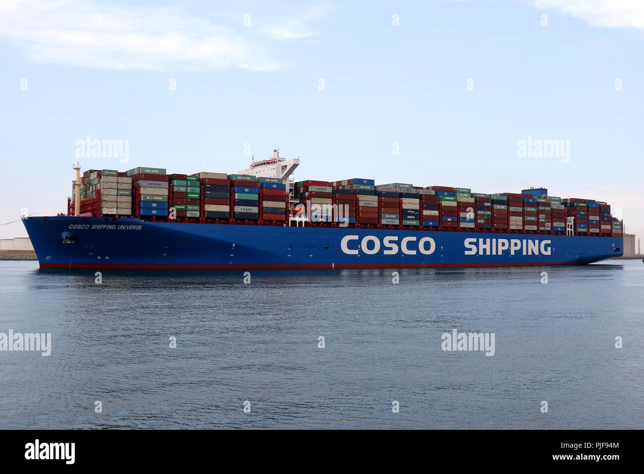 The large container ship COSCO Shipping Universe leaves the port of Rotterdam on 27 July 2018. Stock Photo