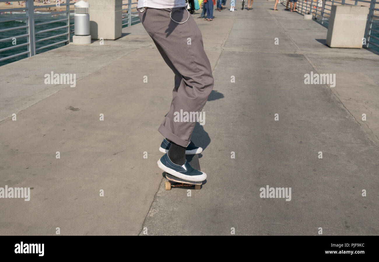 Male skateboarder skates on the pier Stock Photo