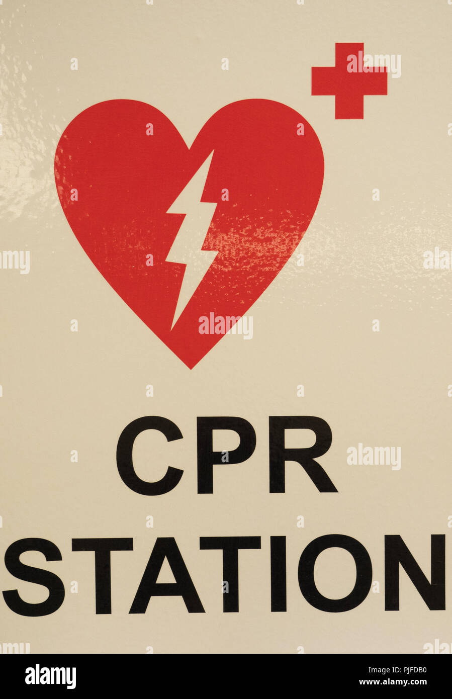 A CPR station sign with a heart, electric shock and red cross design of red on white. Stock Photo