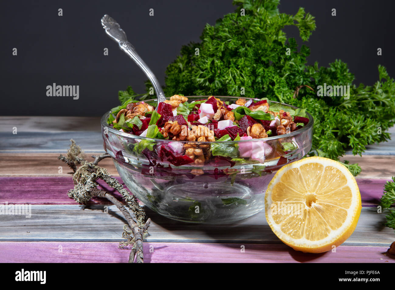 Plate with sald, lemon and greenery on a wooden table Stock Photo