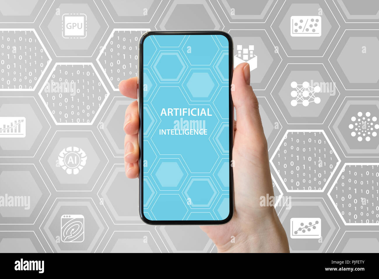 AI / artificial intelligence concept. Hand holding modern frameless smartphone in front of neutral background with icons Stock Photo