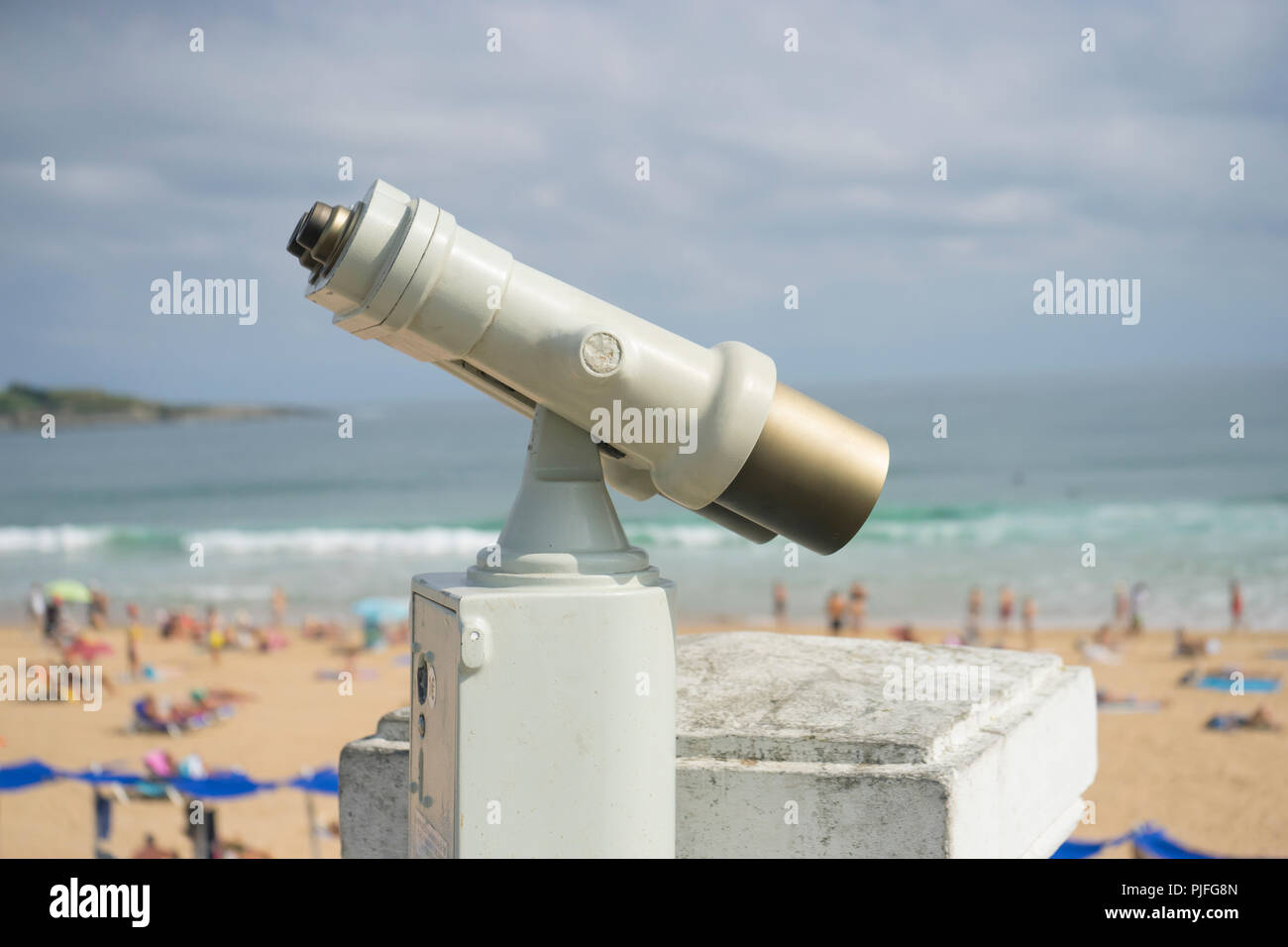 Coin operated binocular on the summer beach, tourist scene in Spain