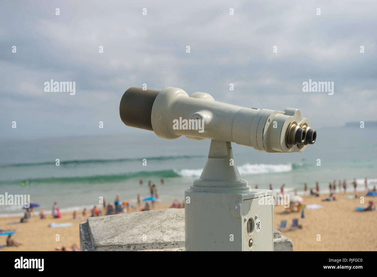 Coin operated binocular on the summer beach, tourist scene in Spain